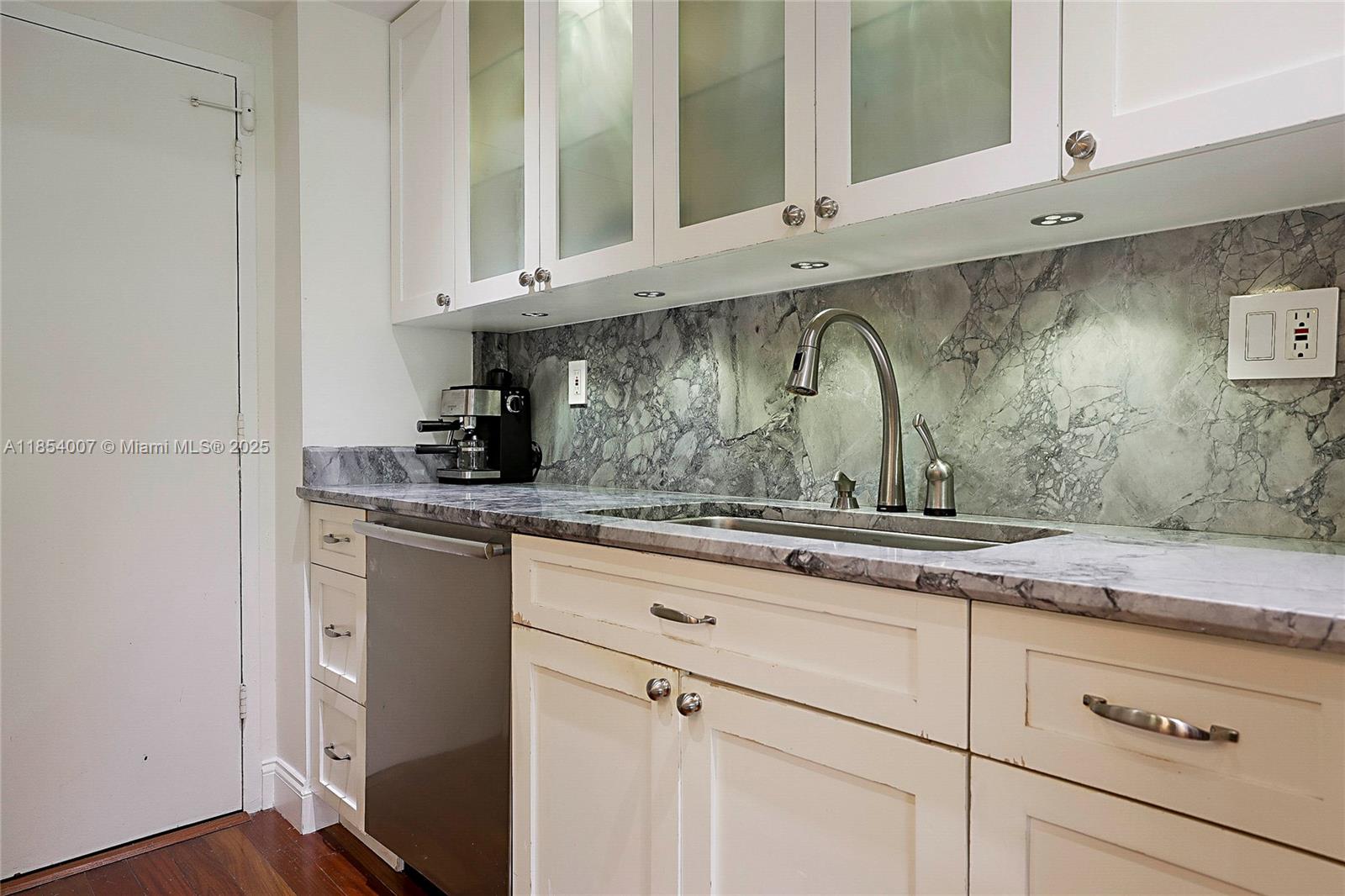 1700 Northeast 105th Street, Unit 203 Miami Shores, FL 33138 - Photo 12 of 45 a kitchen with stainless steel appliances granite countertop white cabinets and a sink