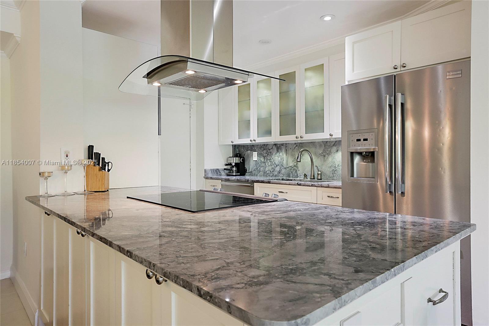 1700 Northeast 105th Street, Unit 203 Miami Shores, FL 33138 - Photo 16 of 45 a kitchen with stainless steel appliances granite countertop a sink and a refrigerator