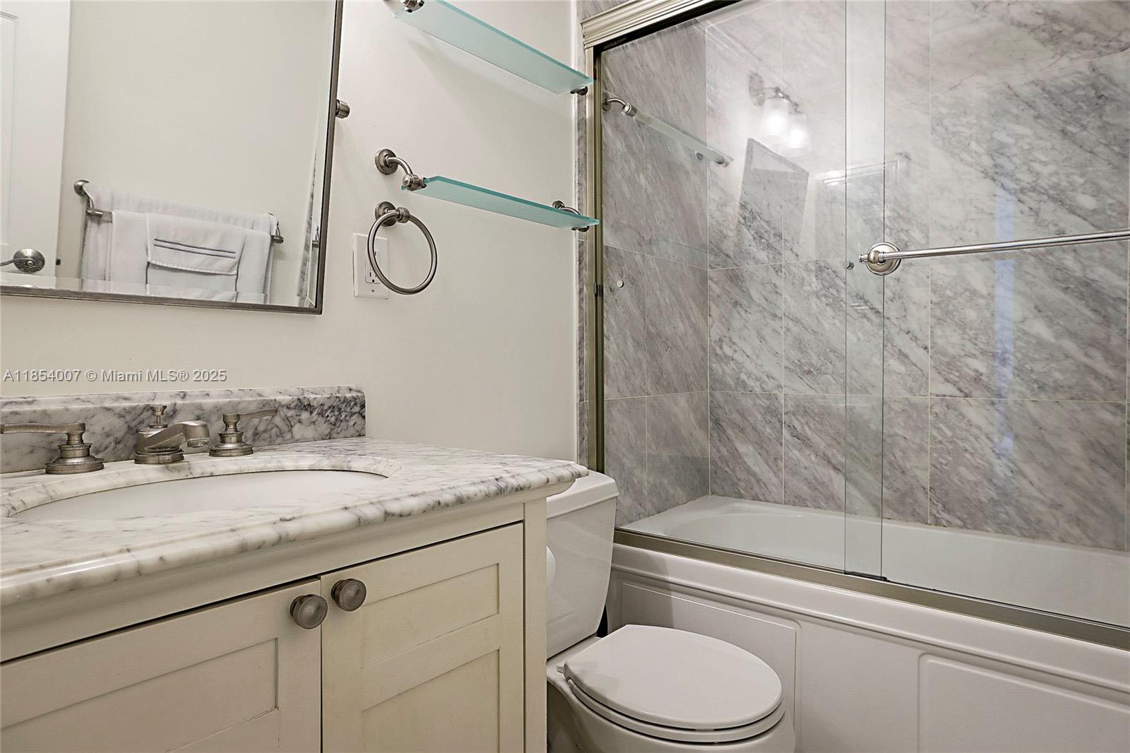 1700 Northeast 105th Street, Unit 203 Miami Shores, FL 33138 - Photo 19 of 45 a bathroom with a granite countertop sink toilet mirror and shower