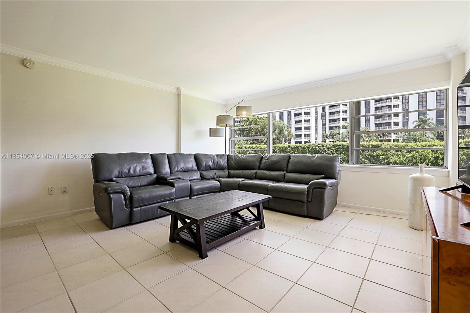 1700 Northeast 105th Street, Unit 203 Miami Shores, FL 33138 - Photo 2 of 45 a living room with furniture and a floor to ceiling window