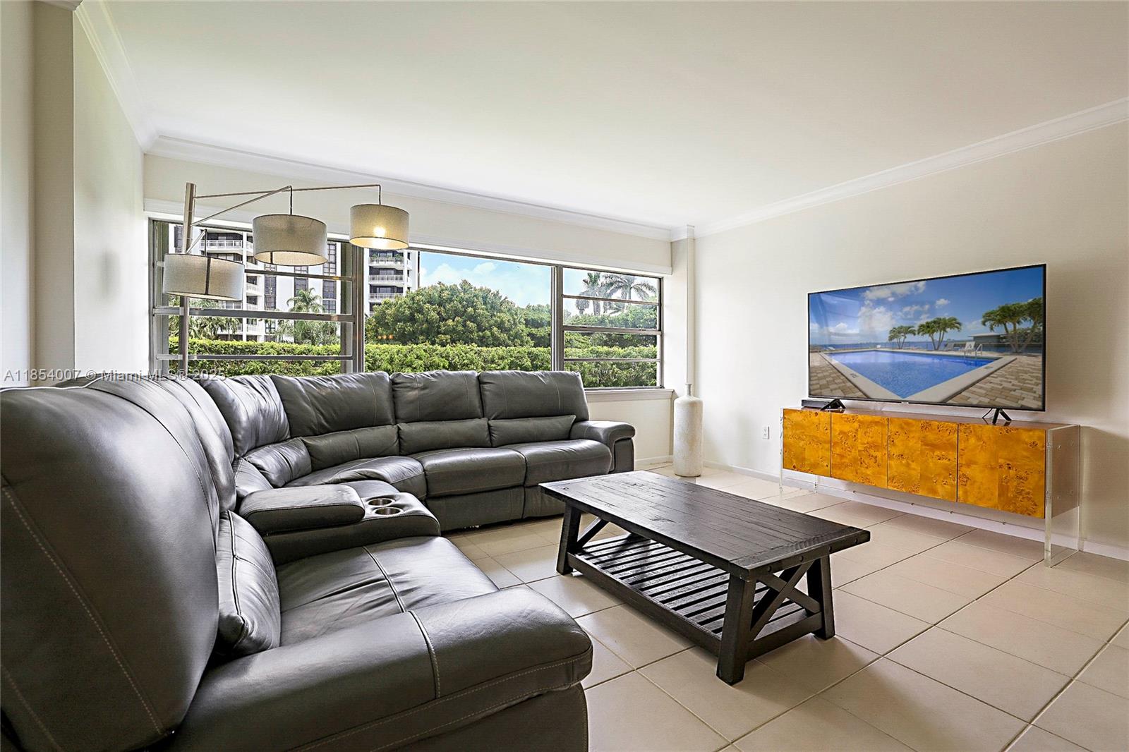 1700 Northeast 105th Street, Unit 203 Miami Shores, FL 33138 - Photo 3 of 45 a living room with furniture a rug and a large window