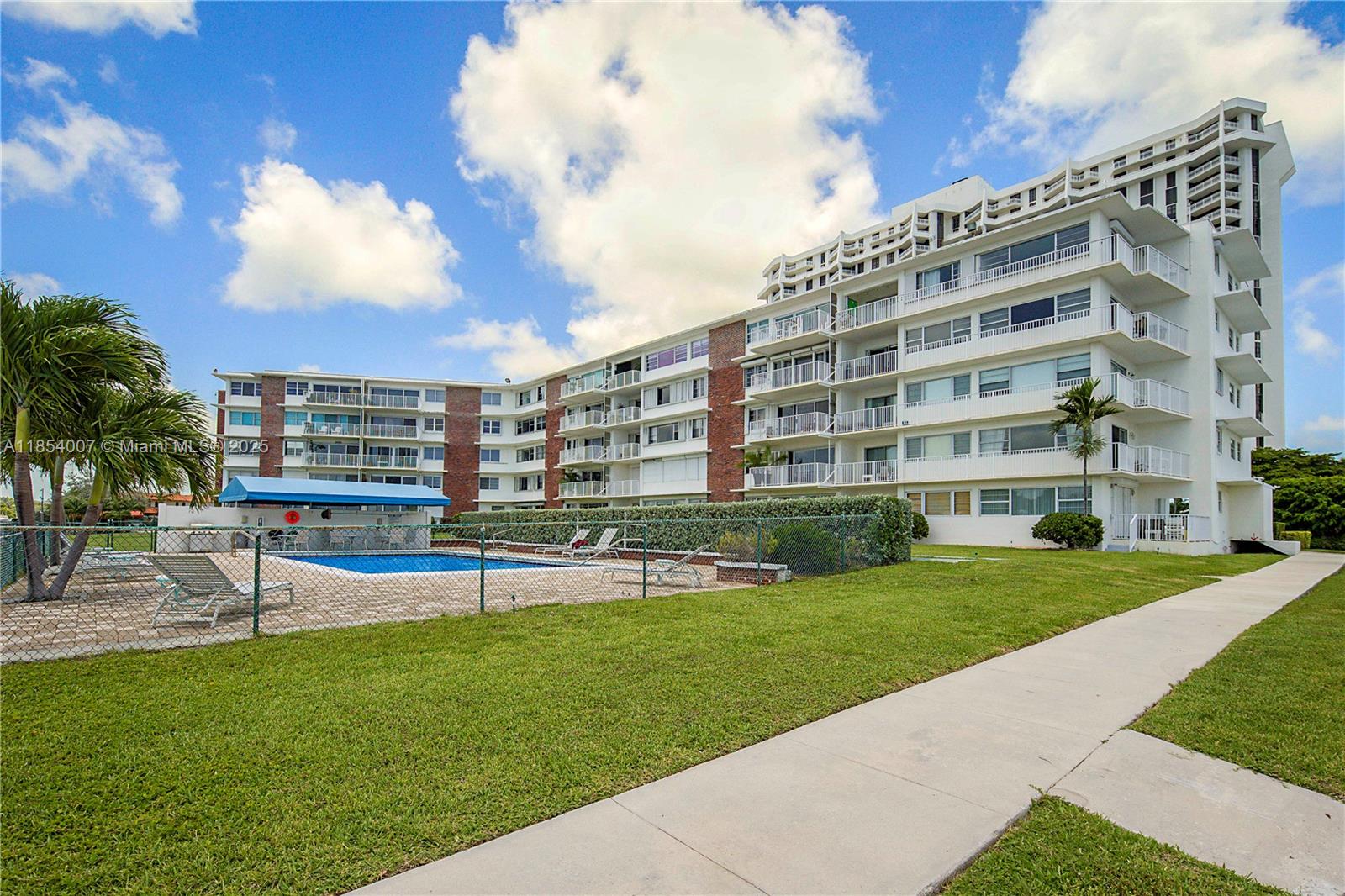 1700 Northeast 105th Street, Unit 203 Miami Shores, FL 33138 - Photo 37 of 45 a view of a building with a big yard and a large tree