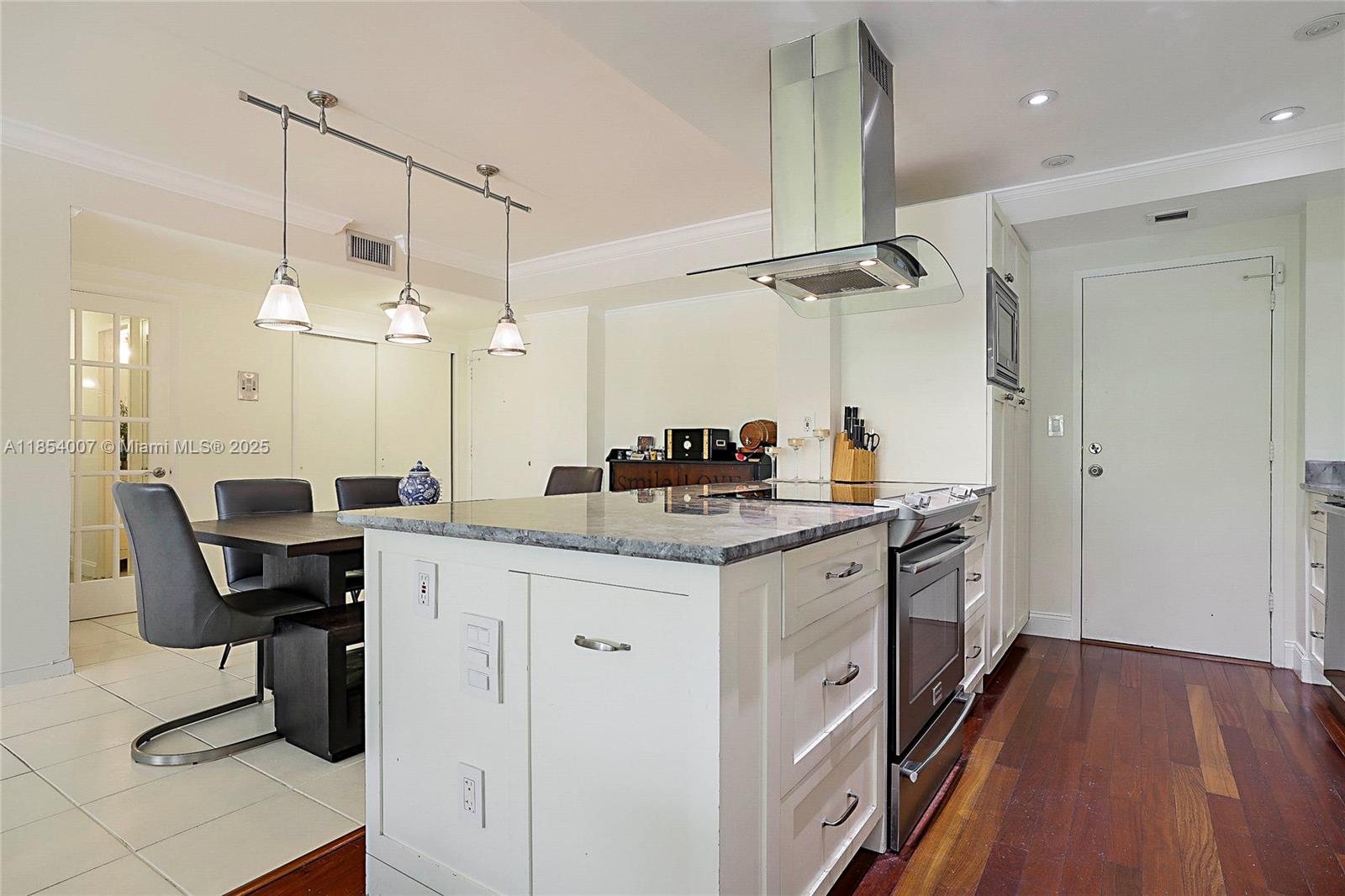 1700 Northeast 105th Street, Unit 203 Miami Shores, FL 33138 - Photo 9 of 45 a kitchen with kitchen island granite countertop a sink a counter top space appliances and cabinets