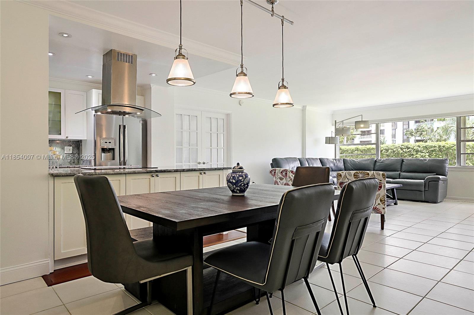 1700 Northeast 105th Street, Unit 203 Miami Shores, FL 33138 - Photo 10 of 45 a dining room with furniture a chandelier and window
