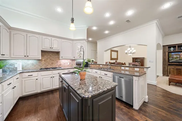 a kitchen with stainless steel appliances granite countertop stove top oven and cabinets