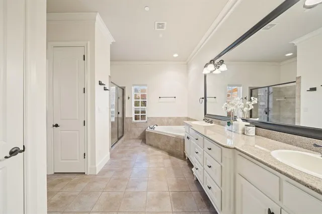 a large white bathroom with a granite countertop sink mirror and a bathtub