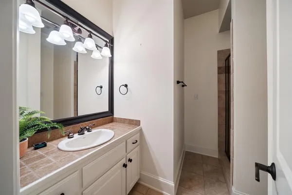 a bathroom with a granite countertop sink and a mirror