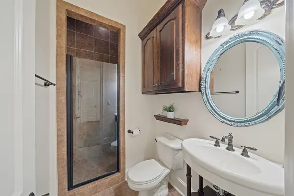 a bathroom with a toilet a sink and a mirror