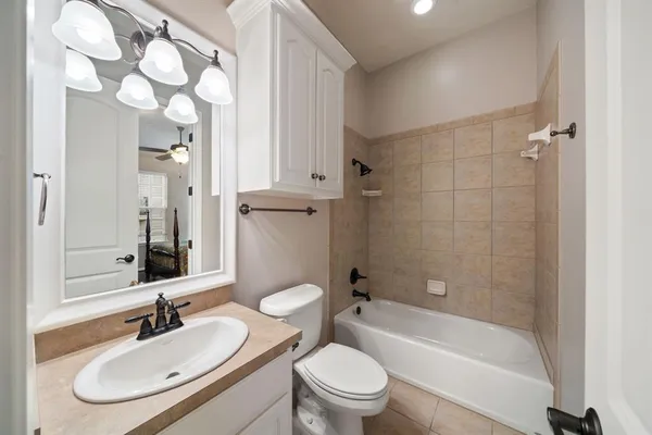 a bathroom with a sink toilet tub vanity and shower