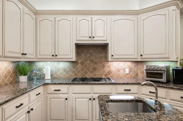 a kitchen with white cabinets and a sink