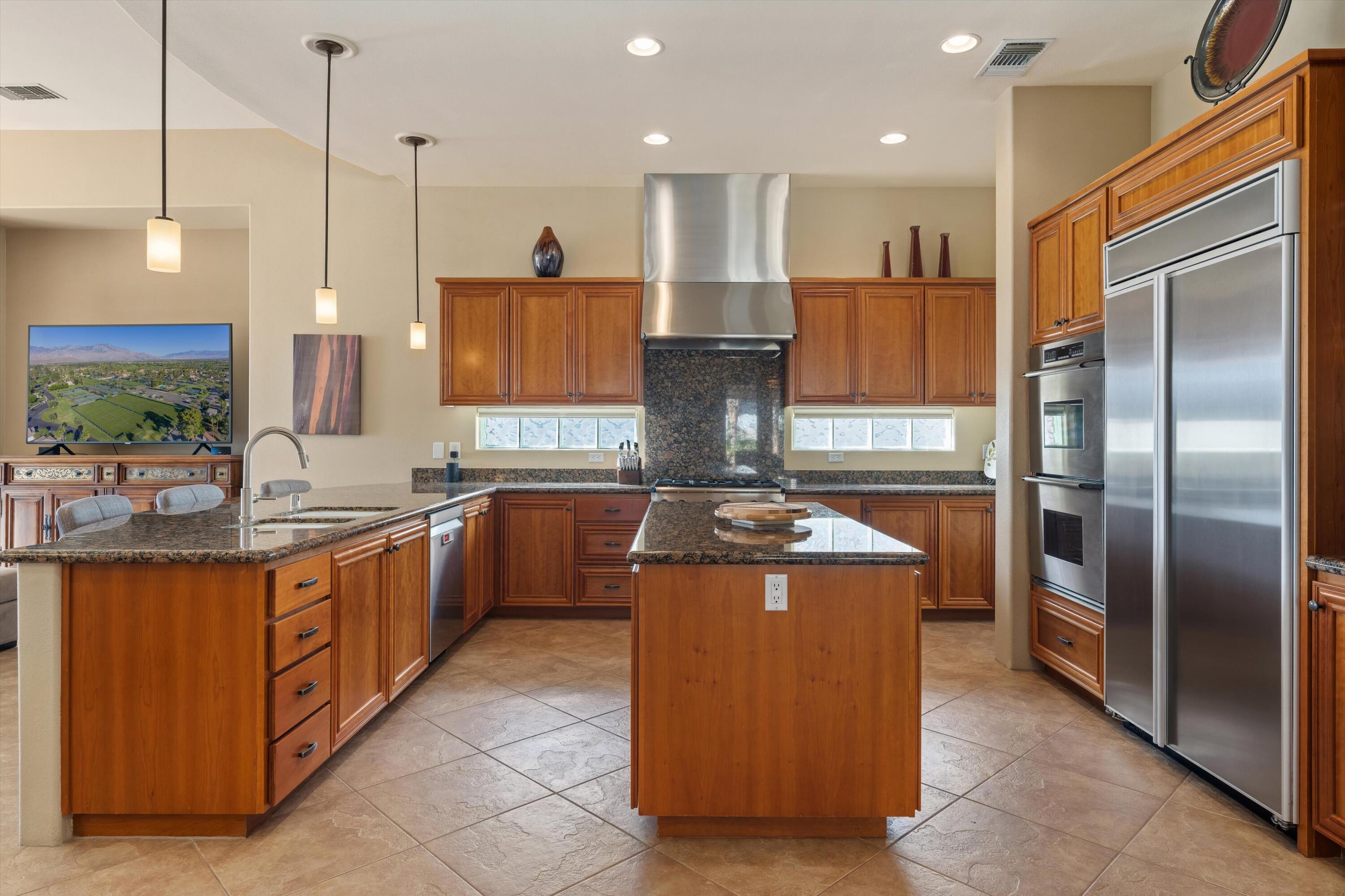 270 Loch Lomond Road Rancho Mirage, CA 92270 - Photo 15 of 51 a kitchen with stainless steel appliances granite countertop a sink a stove and a refrigerator