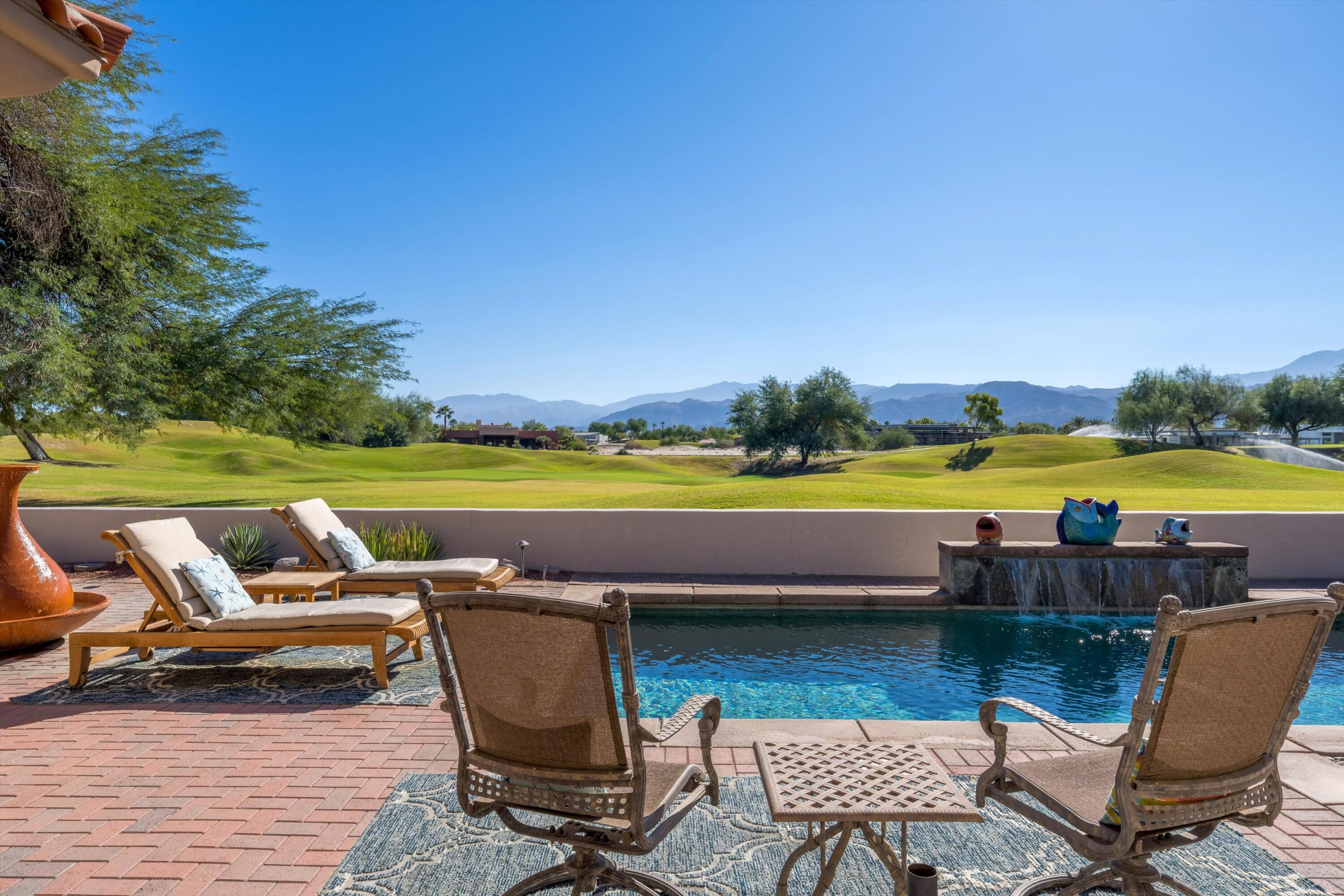 270 Loch Lomond Road Rancho Mirage, CA 92270 - Photo 34 of 51 a roof deck with a table and chairs under an umbrella