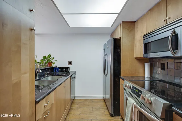 a kitchen with stainless steel appliances granite countertop a sink and a stove