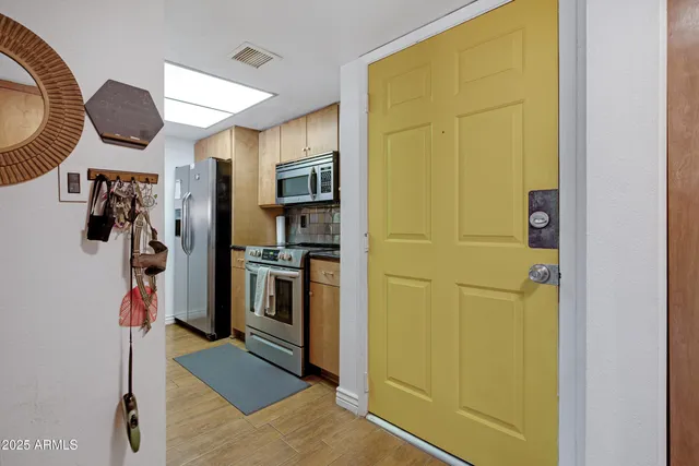 a kitchen with stainless steel appliances granite countertop a refrigerator and a stove top oven