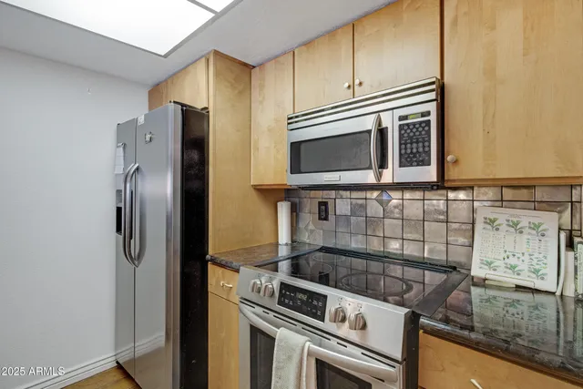 a kitchen with granite countertop a sink and stainless steel appliances