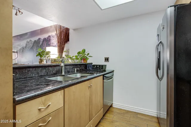 a kitchen with stainless steel appliances granite countertop a sink and a refrigerator