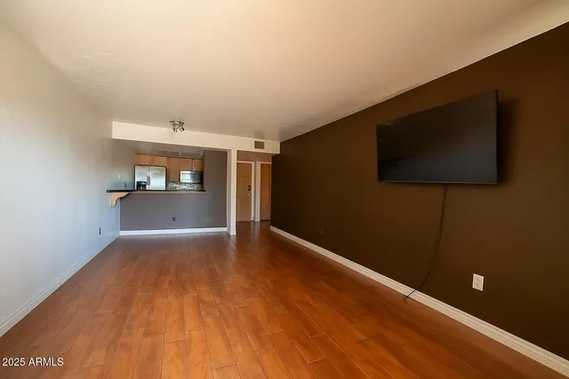 a view of a livingroom with wooden floor and furniture