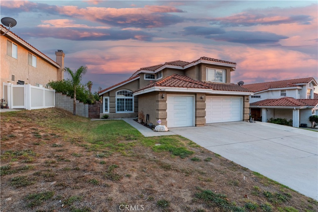 21329 Tennyson Road Moreno Valley, CA 92557 - Photo 2 of 32 a front view of a house with a yard and garage
