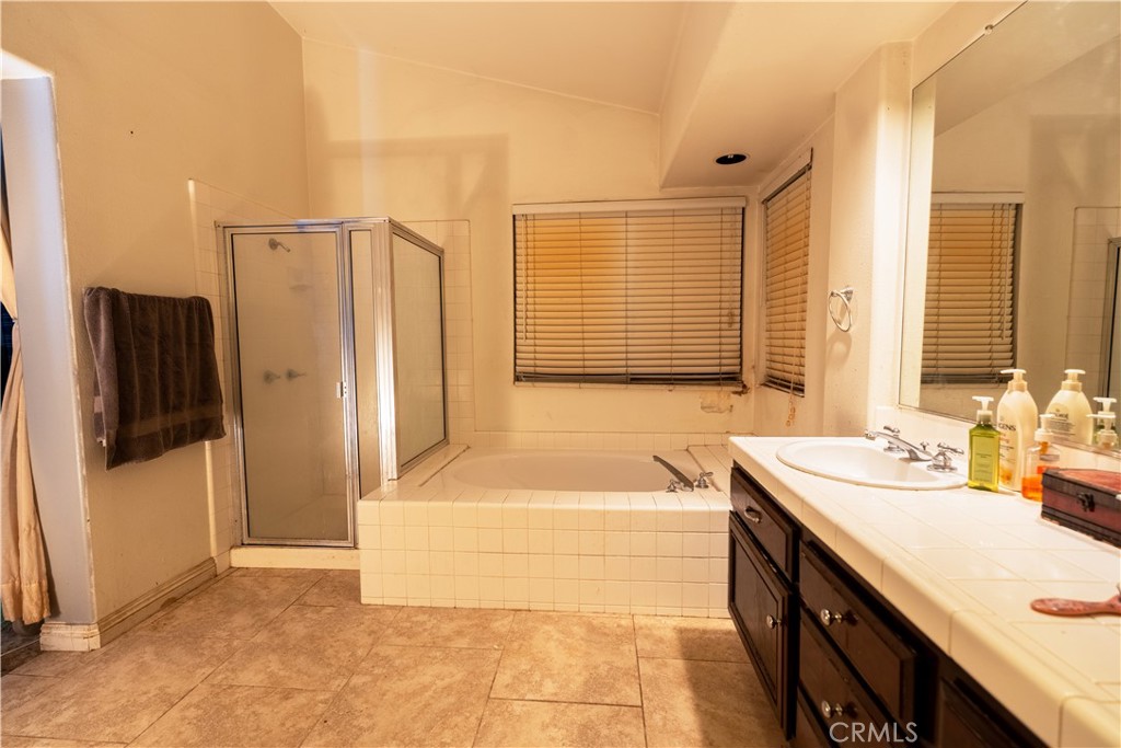 21329 Tennyson Road Moreno Valley, CA 92557 - Photo 28 of 32 a bathroom with a tub sink and a mirror