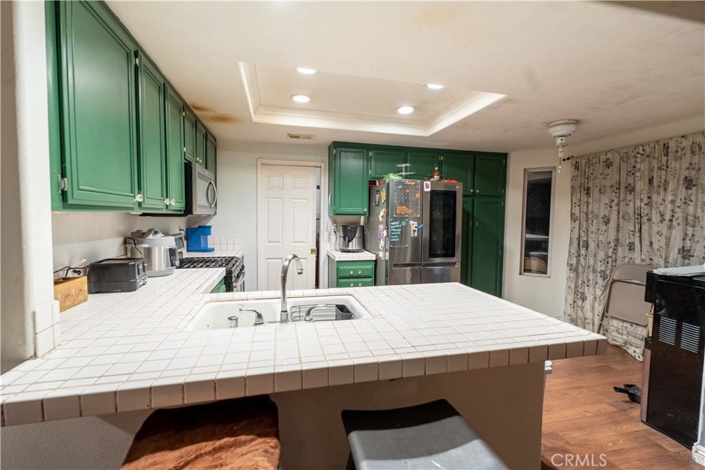 21329 Tennyson Road Moreno Valley, CA 92557 - Photo 10 of 32 a kitchen with stainless steel appliances kitchen island granite countertop a sink and cabinets