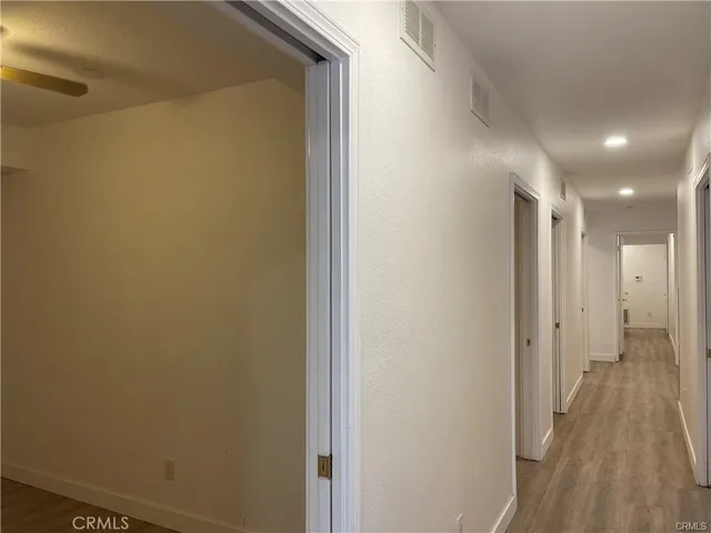 a view of a hallway with wooden floor