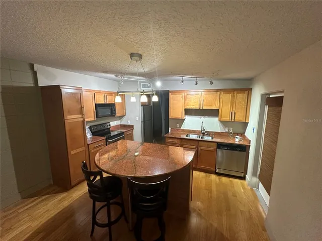 a kitchen with stainless steel appliances granite countertop counter space and a refrigerator
