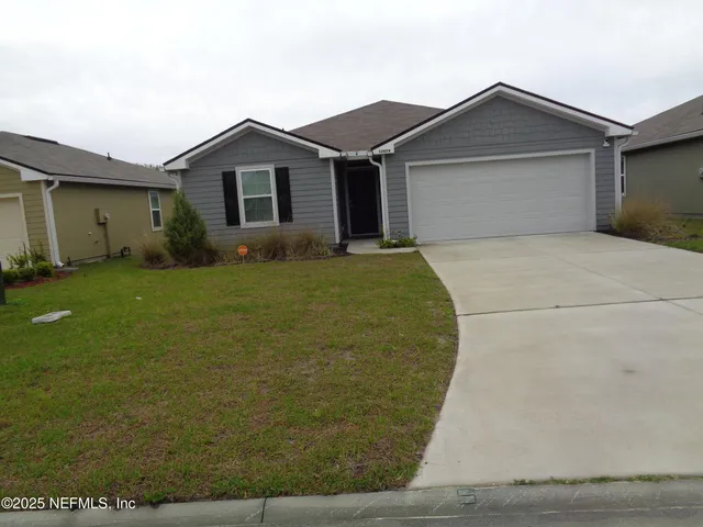 a view of a house with a yard and garage