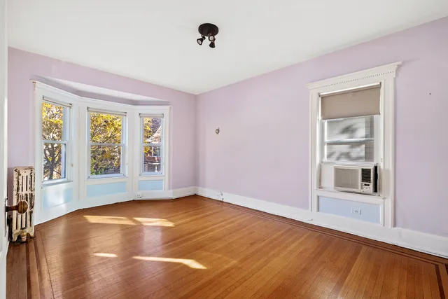 a bedroom with a bed wooden floor and window