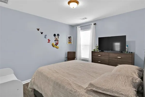 a bedroom with a bed and a flat screen tv