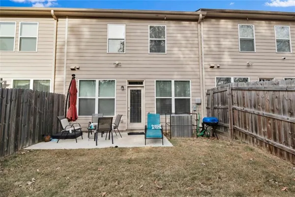 a backyard of a house with dining table and chairs