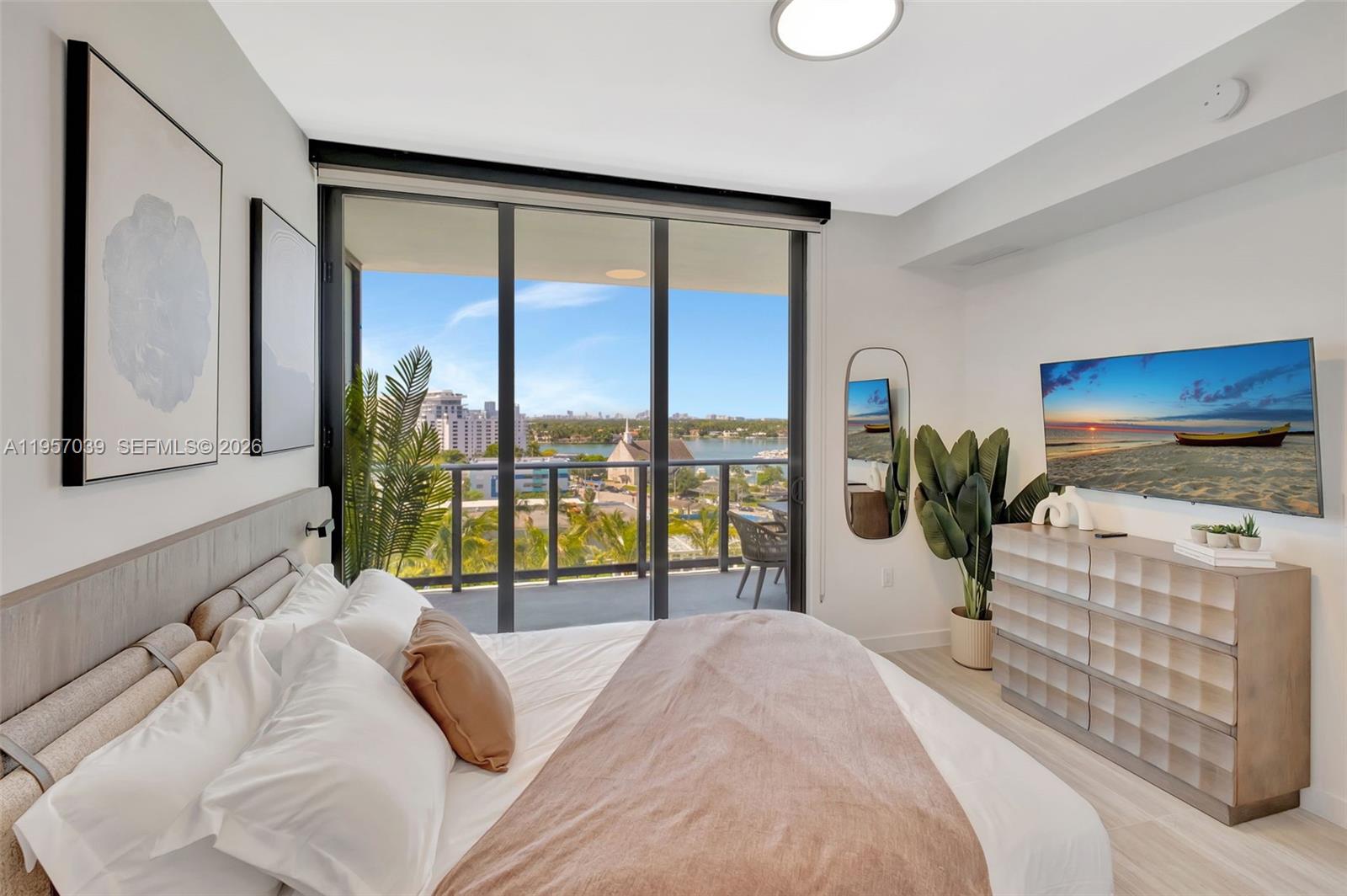 580 72nd Street, Unit 808 Miami Beach, FL 33141 - Photo 13 of 29 a bedroom with a large bed and a flat tv screen