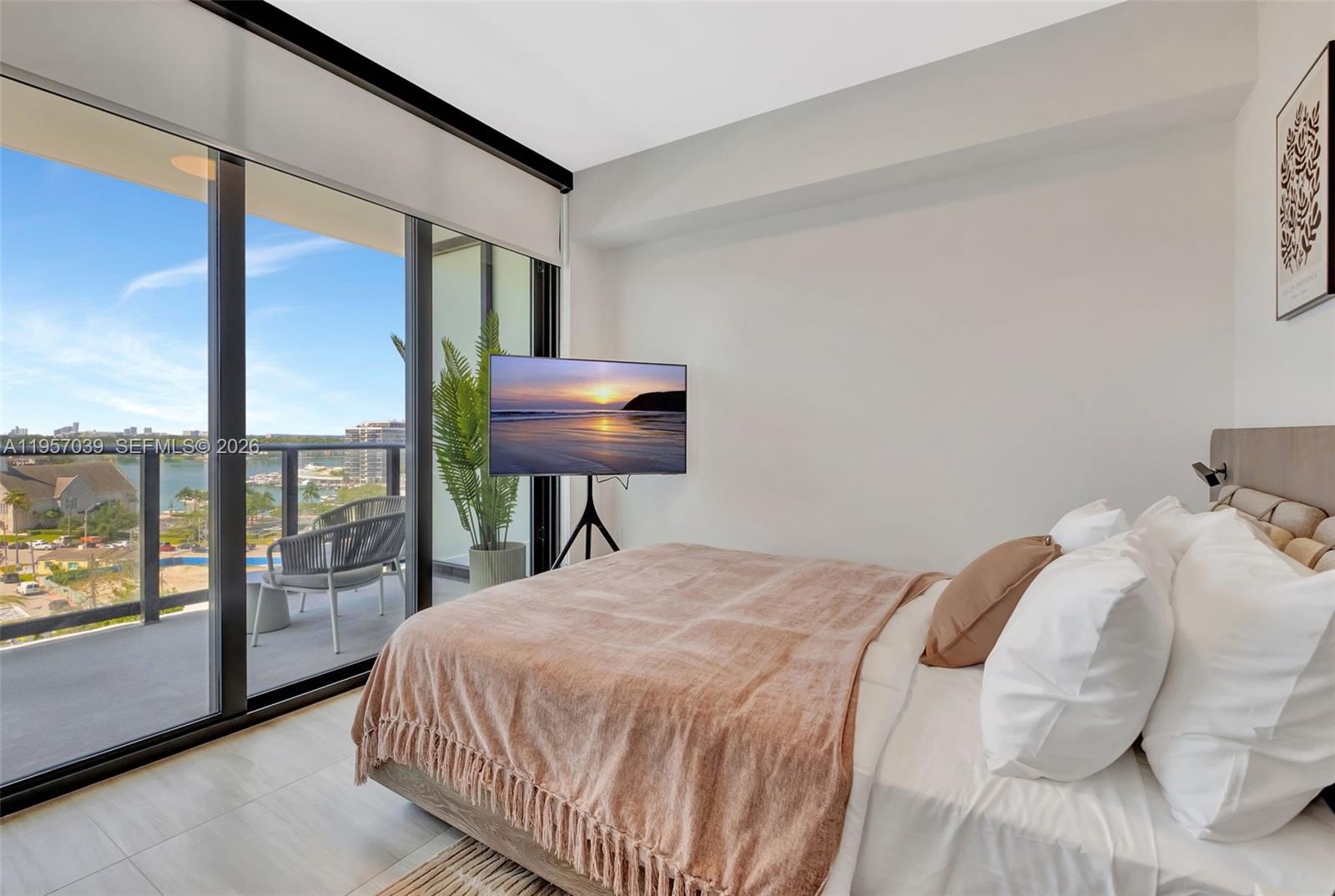 580 72nd Street, Unit 808 Miami Beach, FL 33141 - Photo 16 of 29 a bed sitting in a bedroom next to a window