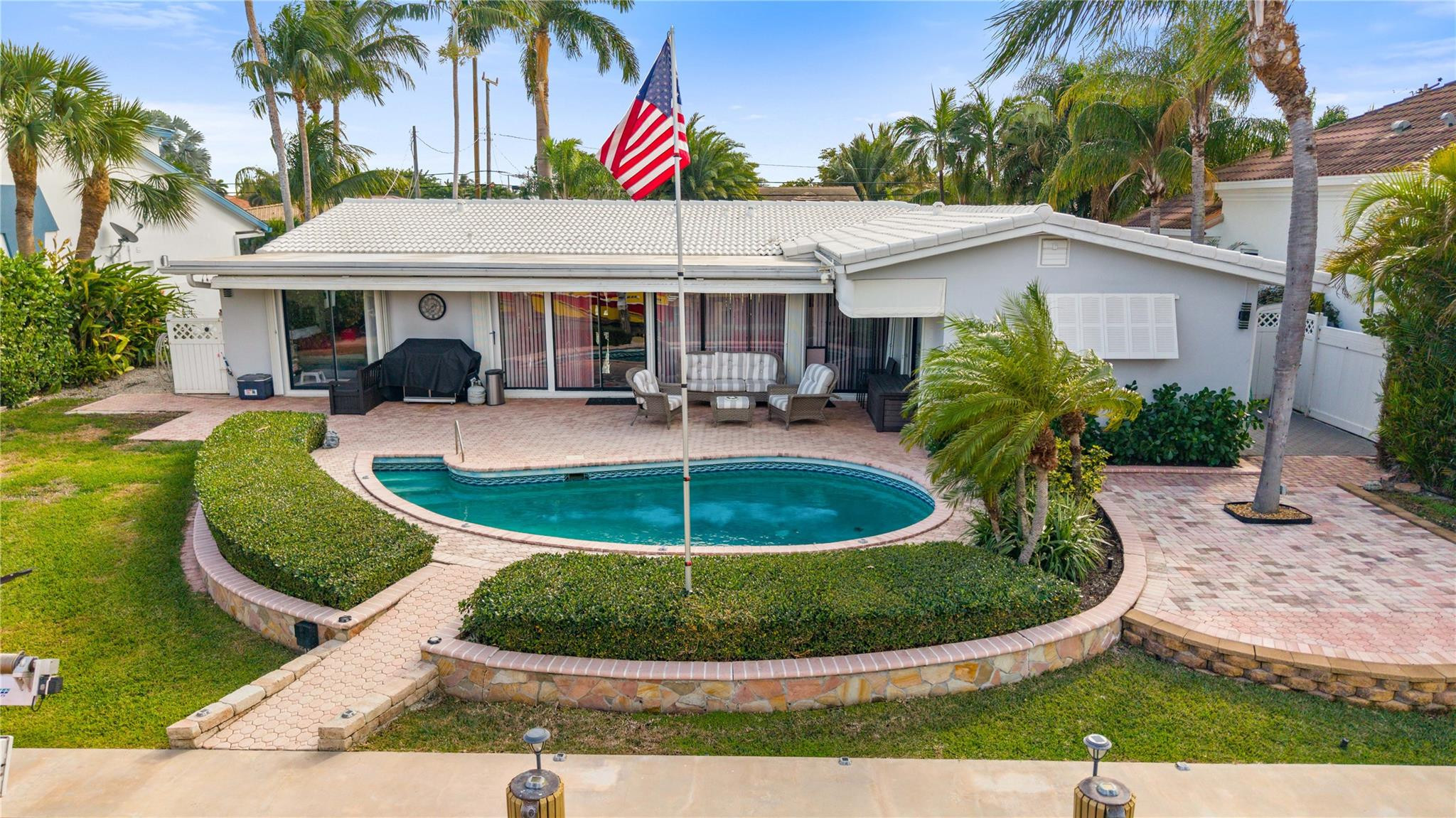 2531 Northeast 47th Street Lighthouse Point, FL 33064 - Photo 2 of 52 a front view of house with yard and seating