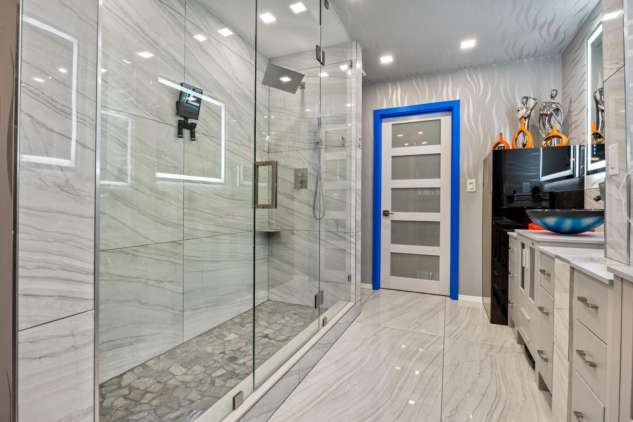 2531 Northeast 47th Street Lighthouse Point, FL 33064 - Photo 31 of 52 a bathroom with a double vanity sink a large mirror and shower