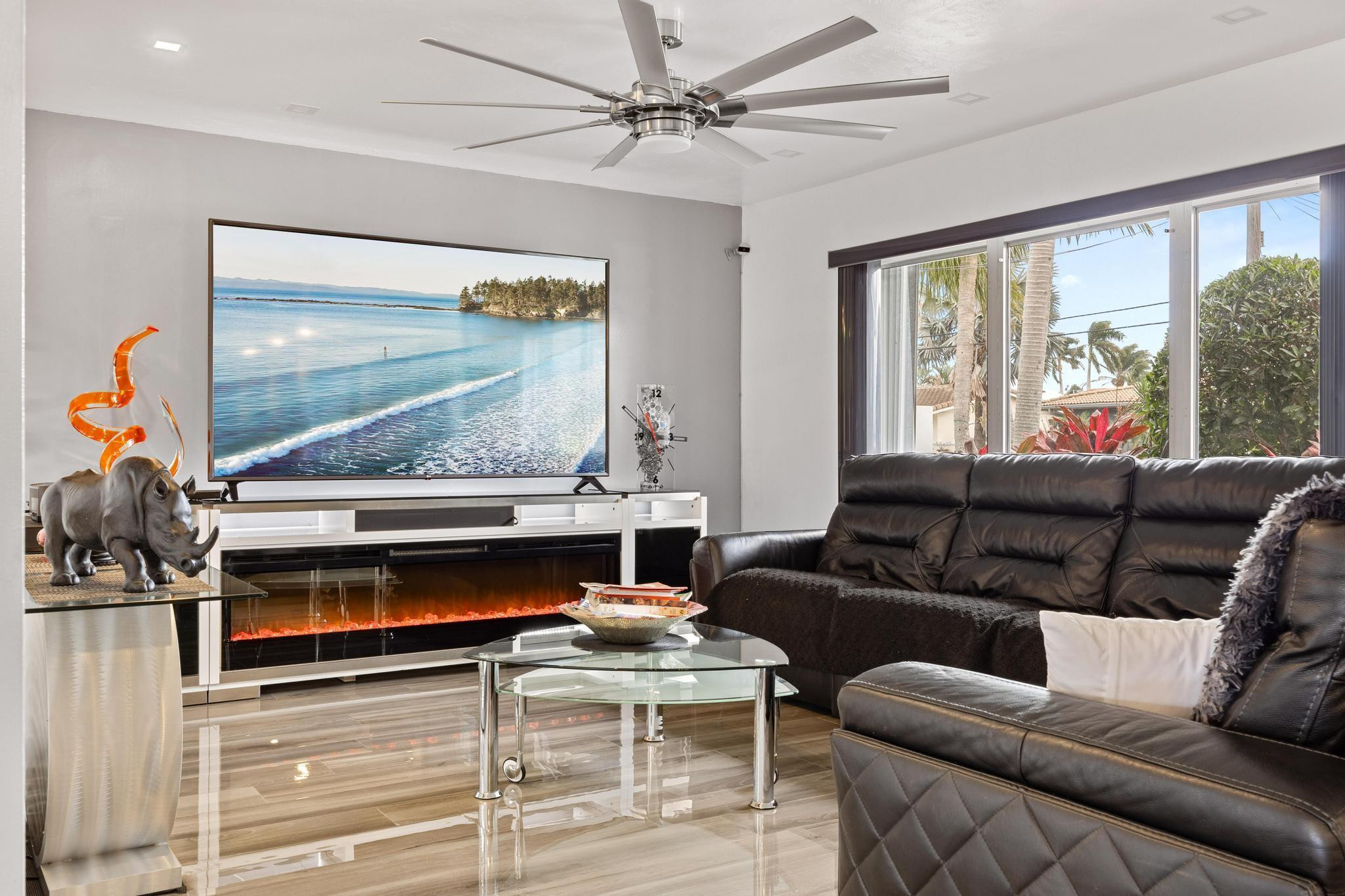 2531 Northeast 47th Street Lighthouse Point, FL 33064 - Photo 32 of 52 a living room with furniture a flat screen tv and a floor to ceiling window