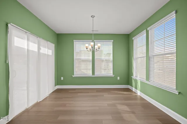 a view of a livingroom with a chandelier fan and kitchen view