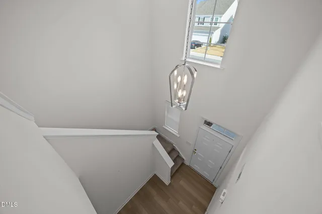 a view of hallway with window and wooden floor