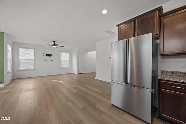 a view of a kitchen with a refrigerator cabinets and wooden floor
