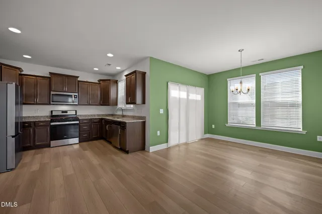 a kitchen with kitchen island granite countertop a sink cabinets and stainless steel appliances