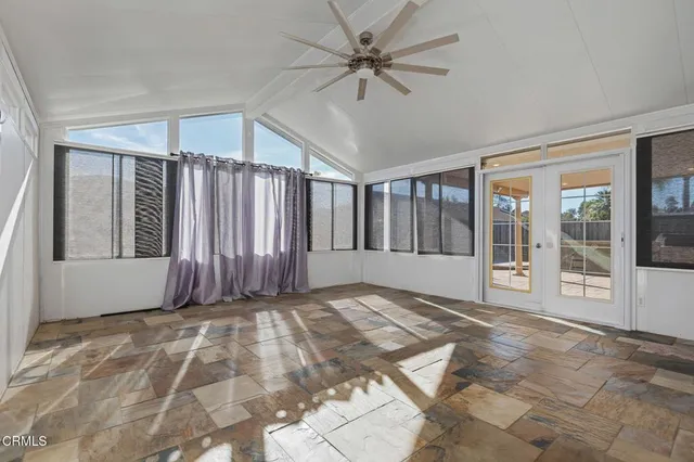 a view of an empty room with a window and a kitchen