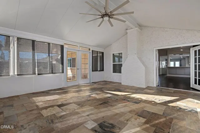 a view of an empty room with window and a kitchen