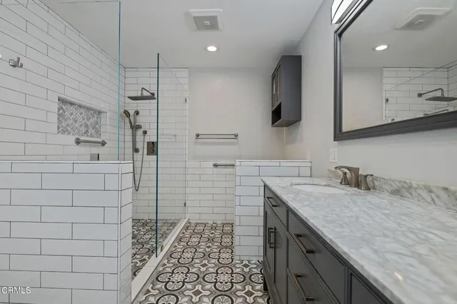 a bathroom with a granite countertop sink a vanity and a shower