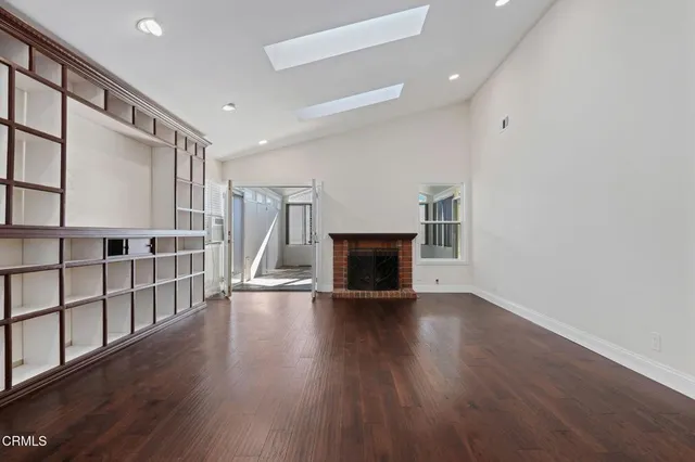 a view of empty room with wooden floor and fireplace