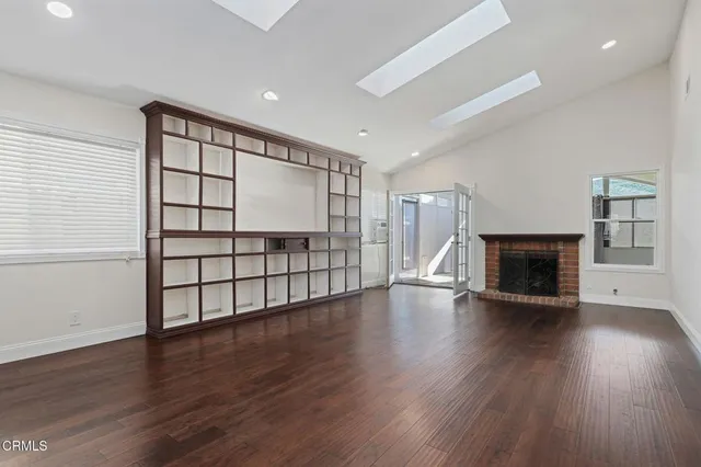 a view of a livingroom with wooden floor and a fireplace