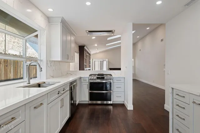 a kitchen with stainless steel appliances granite countertop a sink stove and refrigerator