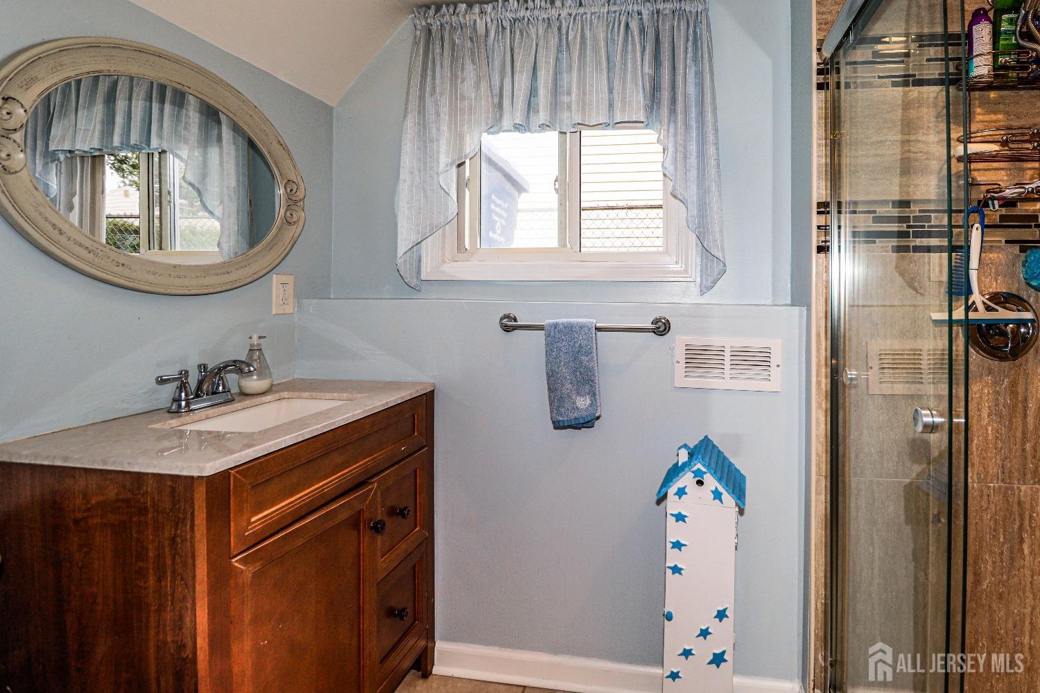 38 Westminster Road Colonia, NJ 07067 - Photo 15 of 24 a bathroom with a sink a mirror and a bathtub