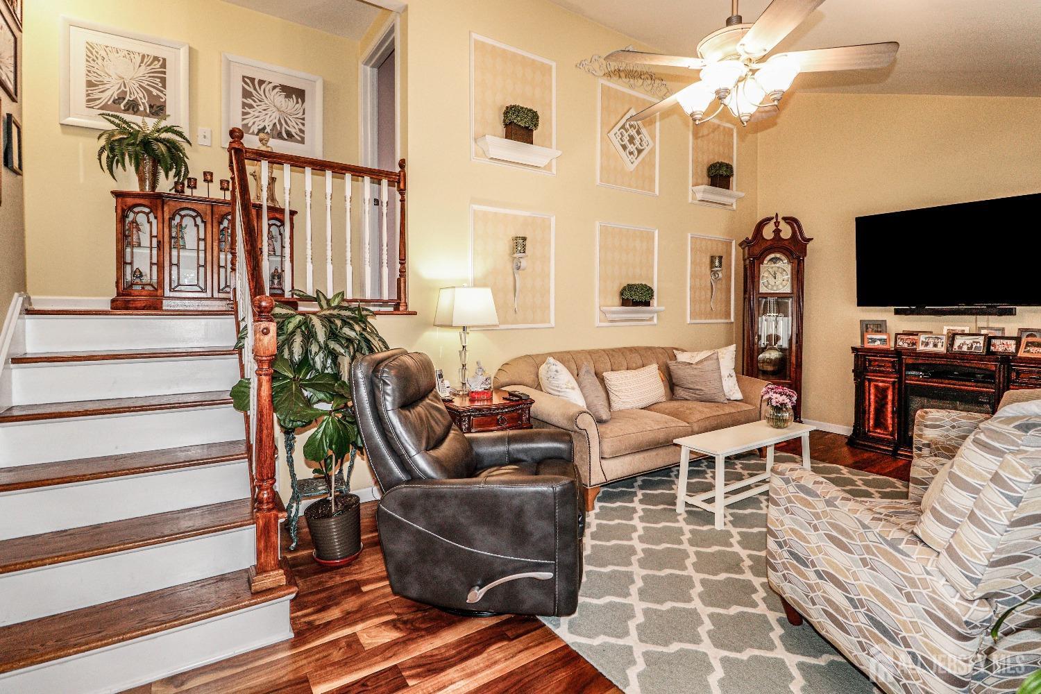 38 Westminster Road Colonia, NJ 07067 - Photo 5 of 24 a living room with furniture a flat screen tv and a floor to ceiling window