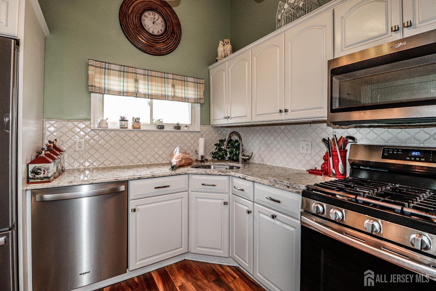 38 Westminster Road Colonia, NJ 07067 - Photo 8 of 24 a kitchen with stainless steel appliances a stove a microwave and cabinets