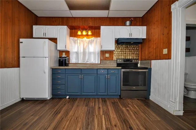a kitchen with wooden cabinets and white appliances