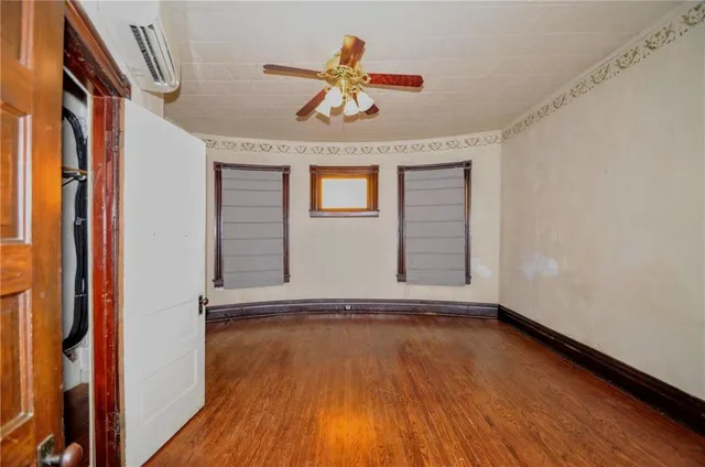 a view of a hallway with wooden floors and a chandelier